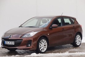 Ein hellbrauner Mazda 3 im Winter vor einer Werkstatt