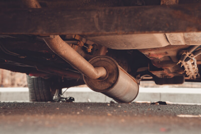 Nahaufnahme eines defekten Auspuff am Auto