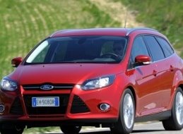 Ein roter Ford Focus fährt aus einer Werkstatt nach der Reparatur des Außenspiegels