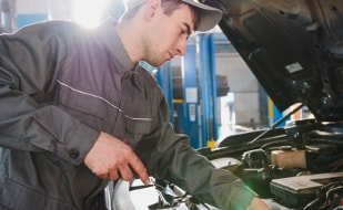 Fachmann beim Motorcheck bei der Suche, warum der verliert Öl