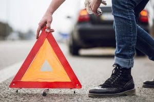 Absicherung der Unfallstelle: Ein Warndreieck am rechten Fahrbahnrand aufgestellt.