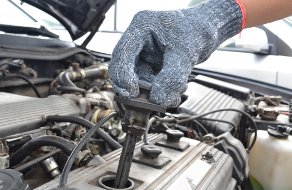 Fachmann beim Wechsel der Zündkerzen beim BMW in einer Werkstatt