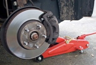 Nahaufnahme der Bremsanlage eines Peugeot beim Wechsel in der Werkstatt