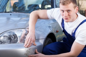 Begutachtung eines Lackschadens an einem grauen Auto