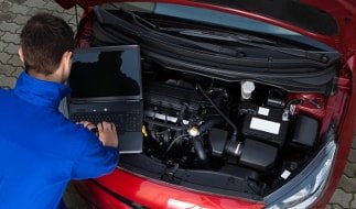 Fachmann bei der großen Inspektion eines Peugeot in der Werkstatt 