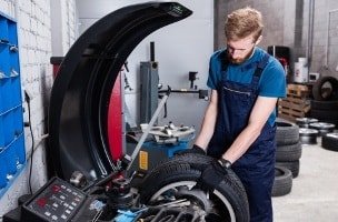 Fachmann beim Auswuchten der Reifen in der Fachwerkstatt