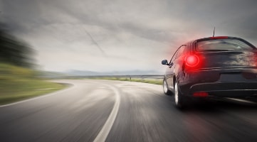 Ein schwarzes Auto fährt mit der hohen Geschwindigkeit